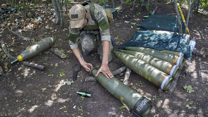 Ukrajinský vojak pripravuje náboje do americkej ťažnej húfnice M777 ráže 155 mm neďaleko Charkova. [EPA-EFE/Sergej Kozlov]
